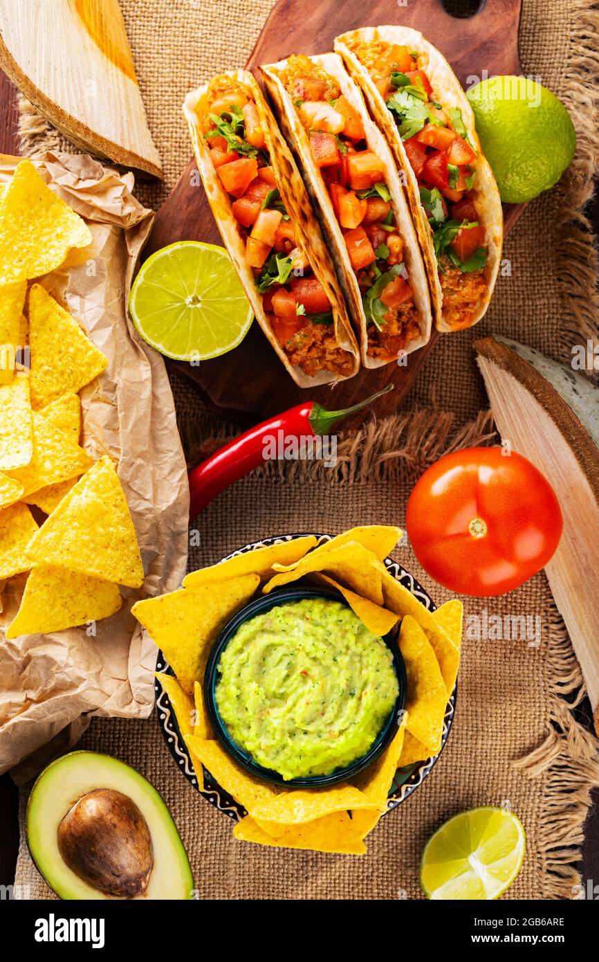 Tacos, tortilla chips with guacamole, lime and tomato
